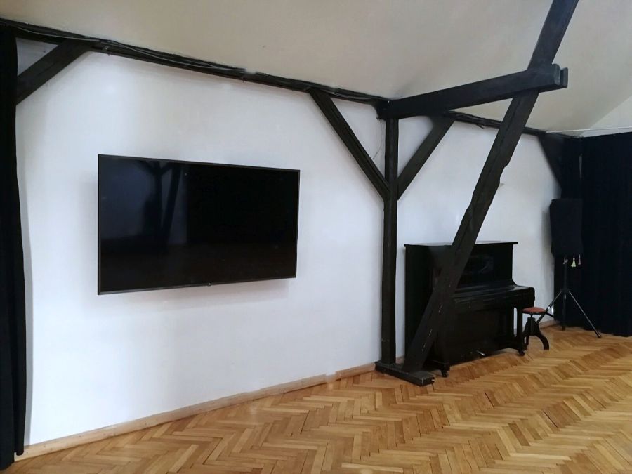 Seminarraum in Bremen mit 75-Zoll-Bildschirm für Präsentationen, Klavier und Fachwerkbalken